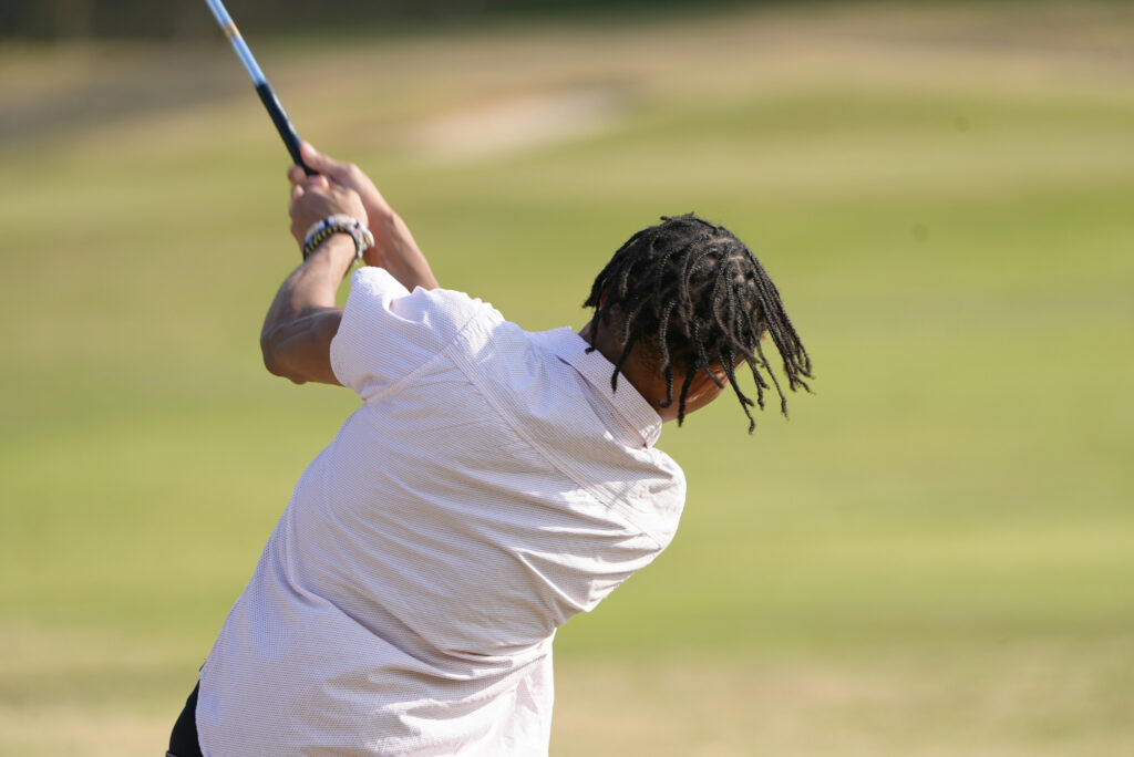 gather golfer swinging towards the green